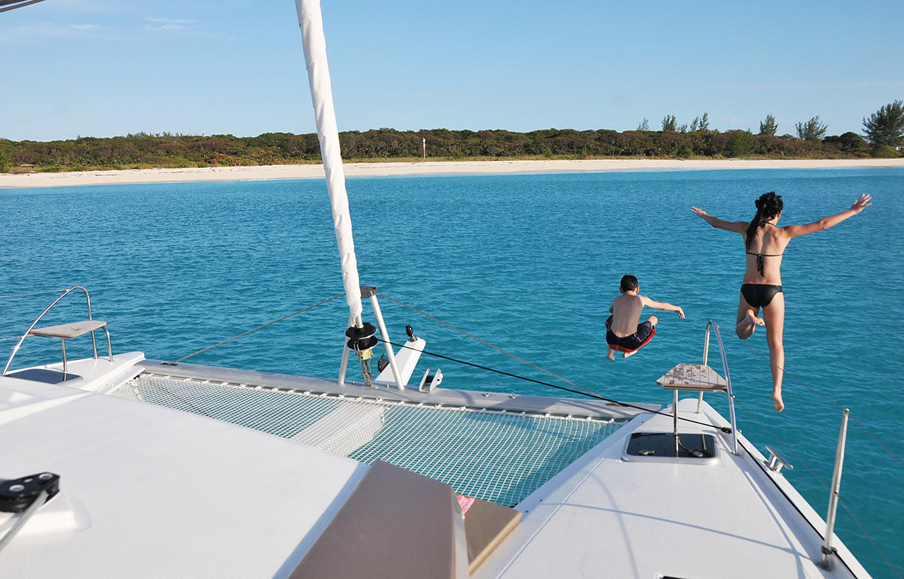 Passengers diving off the bow of Aquaholic Yacht Charter
