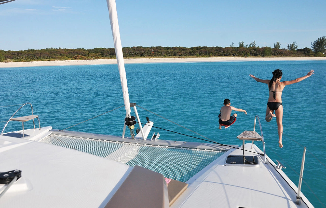 Passengers diving off the bow of Aquaholic Yacht Charter