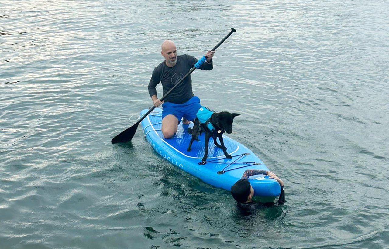 luxury charter guests and a dog on AQUAHOLIC's stand-up paddleboard