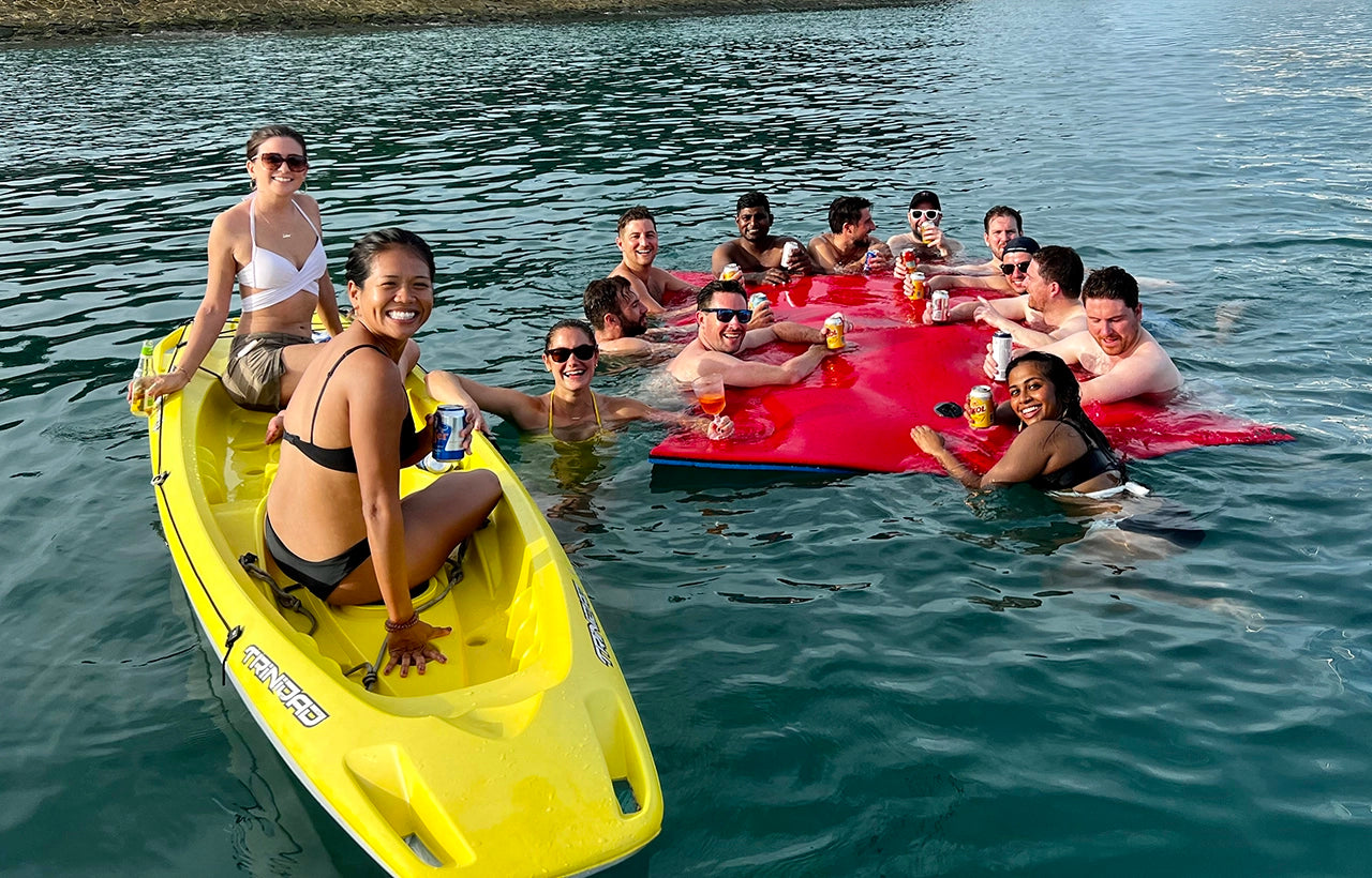 luxury charter guests enjoying drinks on watermat and a double kayak