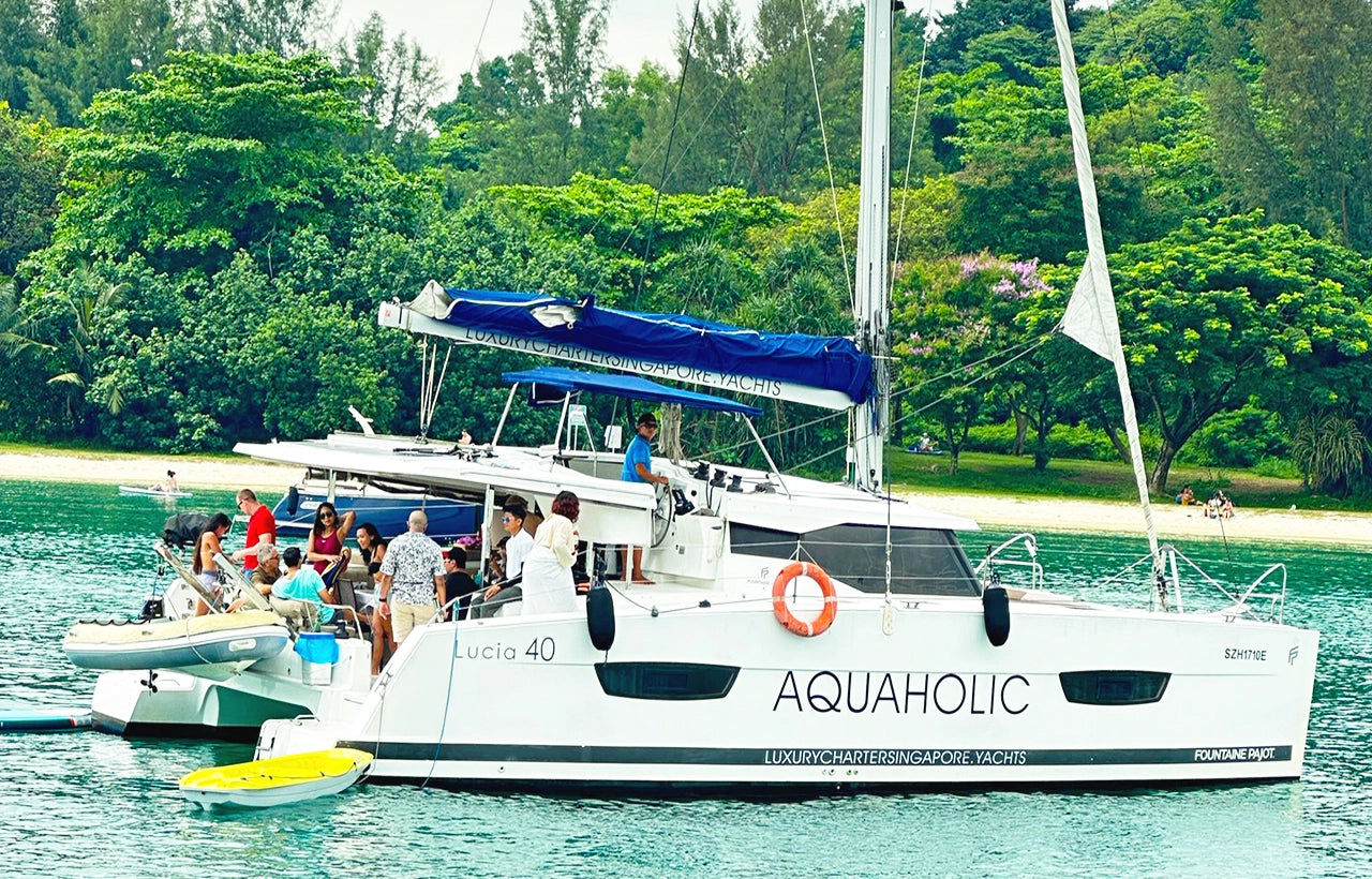 AQUAHOLIC Charter yacht with guests enjoying drinks and music at the stern