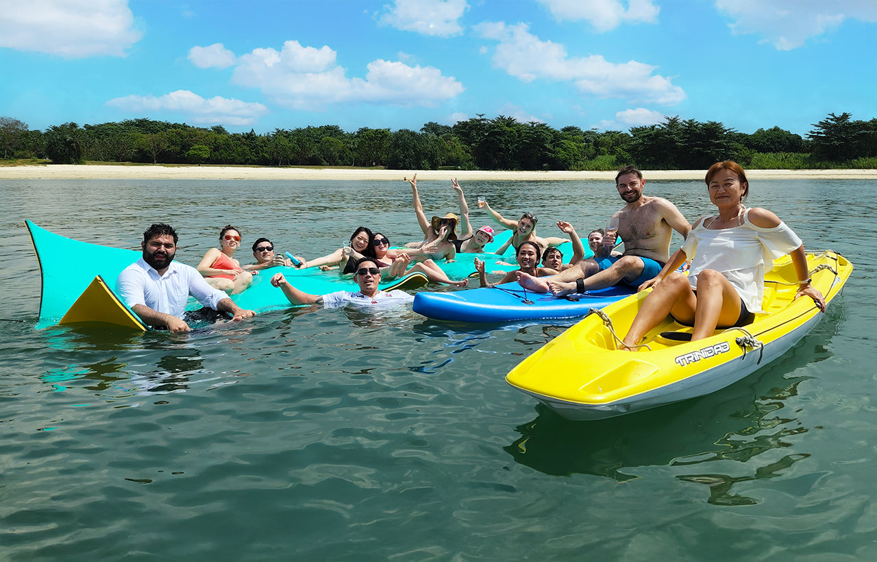 group enjoying AQUAHOLIC's watertoys, watermat, standup paddle boards and double kayak
