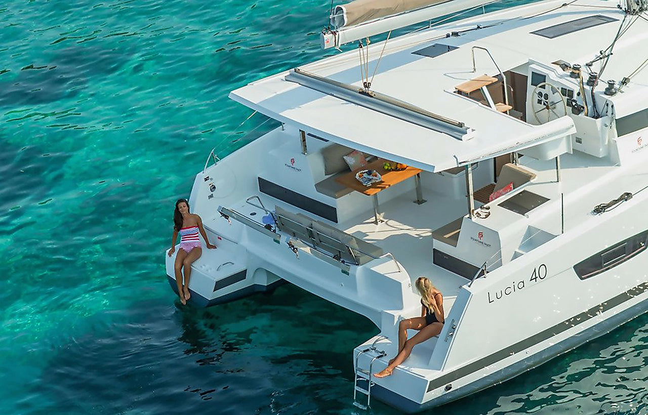 AQUAHOLIC Charter yacht with guests relaxing at the stern